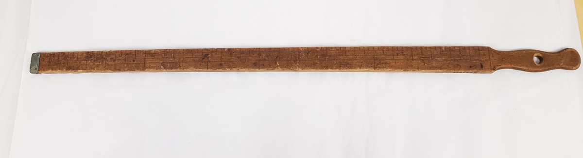 Et smalt stykke tre med gjentakende markeringer innrisset i stykket