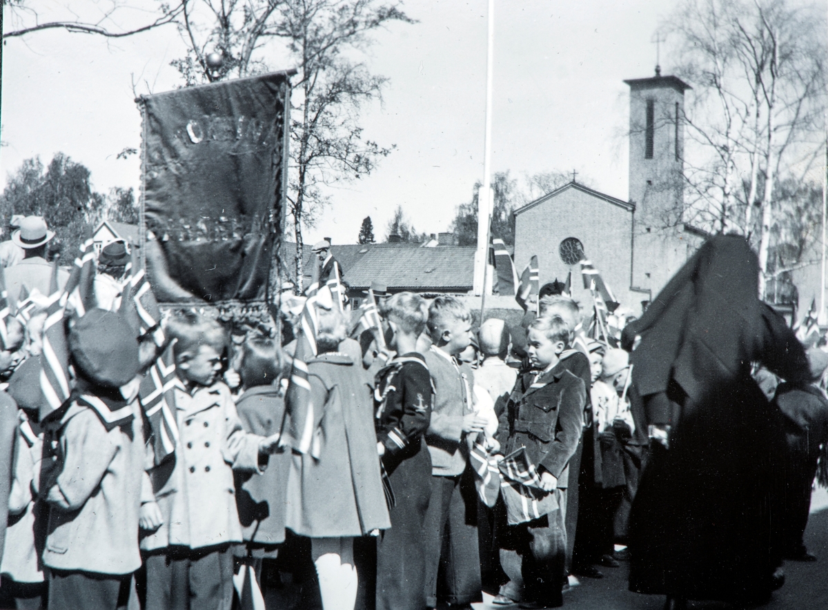 17. mai tog, 1953. Tatt i Heidmanns gate med St. Torfinn kirke,  og daværende Prestegård for den katolske menigheten i Hamar.  Torggata 113 i bakgrunnen.
Ved starten av "Skoletoget" 17. mai 1952. Barn fra St. Torfinn barnehage med fanen.