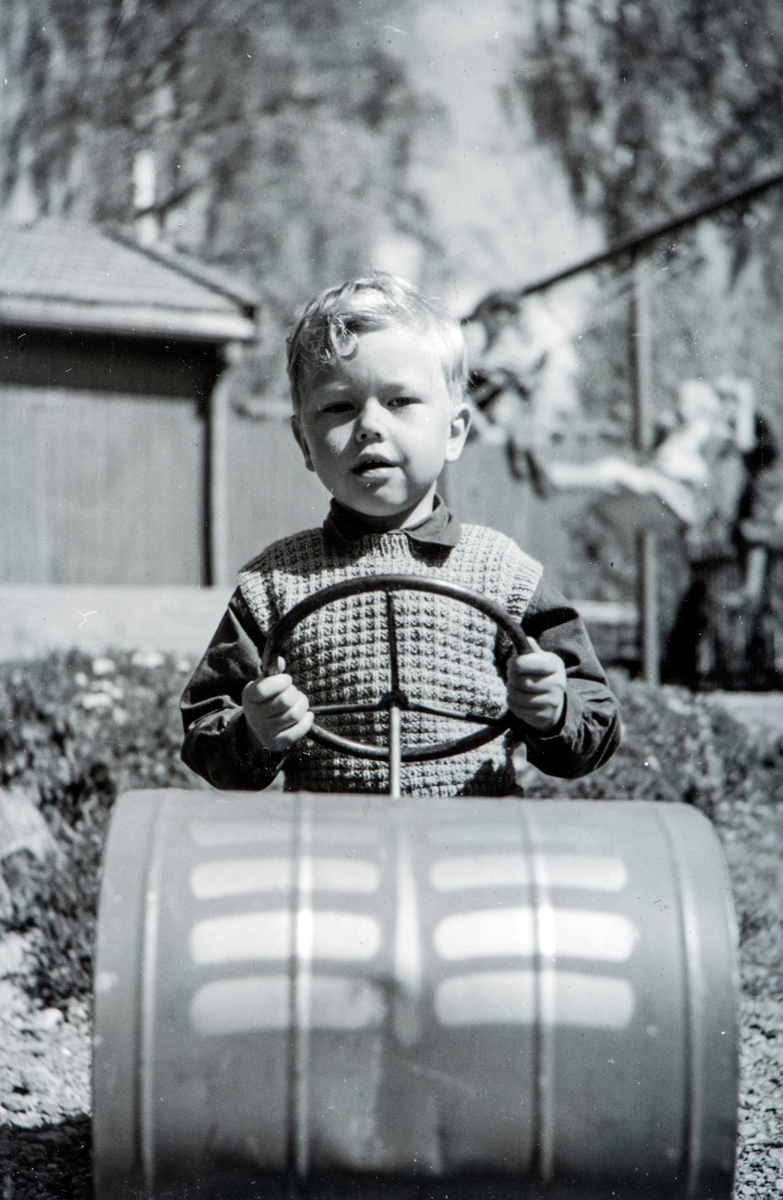 Barn og tråkkebil. Arne Hesselberg i sin tråkkebil, bemerk en liten bulk i fronten.
Inne i haven til "Det katolske kvartalet" Torggata 113 m.m. rundt 1952. 
Individuelle bilder av barna i barnehagen, ble tatt av fotograf, der alle barna fikk låne Arne Hesselbergs tråbil.
Foto tatt mot nordøst, i bakgrunnen det østre hjørnet av uthuset som lå med baksiden mot Grønnegata 134, Dillegården. Til høyre huskene til barnehagen.