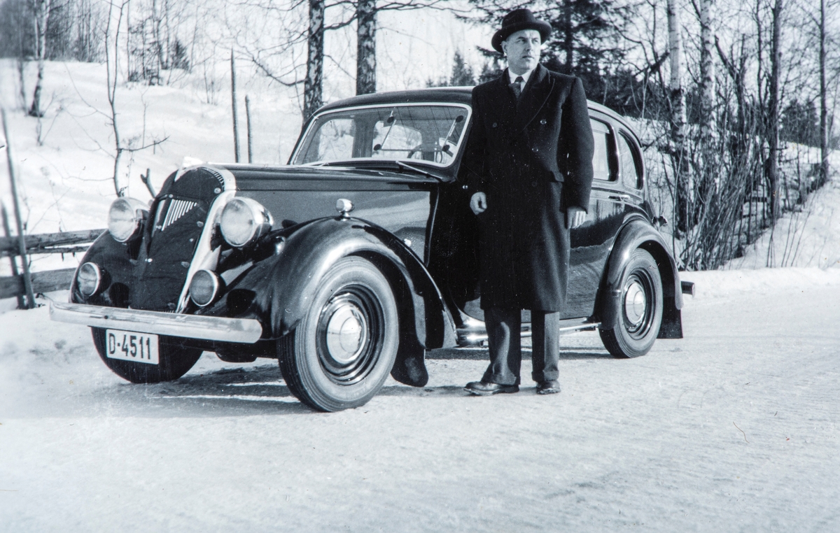 Charles Hesselberg står ved siden av sin egen bil, reg.nr: D-4511. Vinter, snø.
Bilen er en Standard (engelsk merke), antagelig modell 14 (tallet står for engelske skattehestekrefter), årsmodell 1946-48. I Hvem eier bilen 1948 står D-4511 på Gerhard Parthe, Hamar som Standard personbil.
