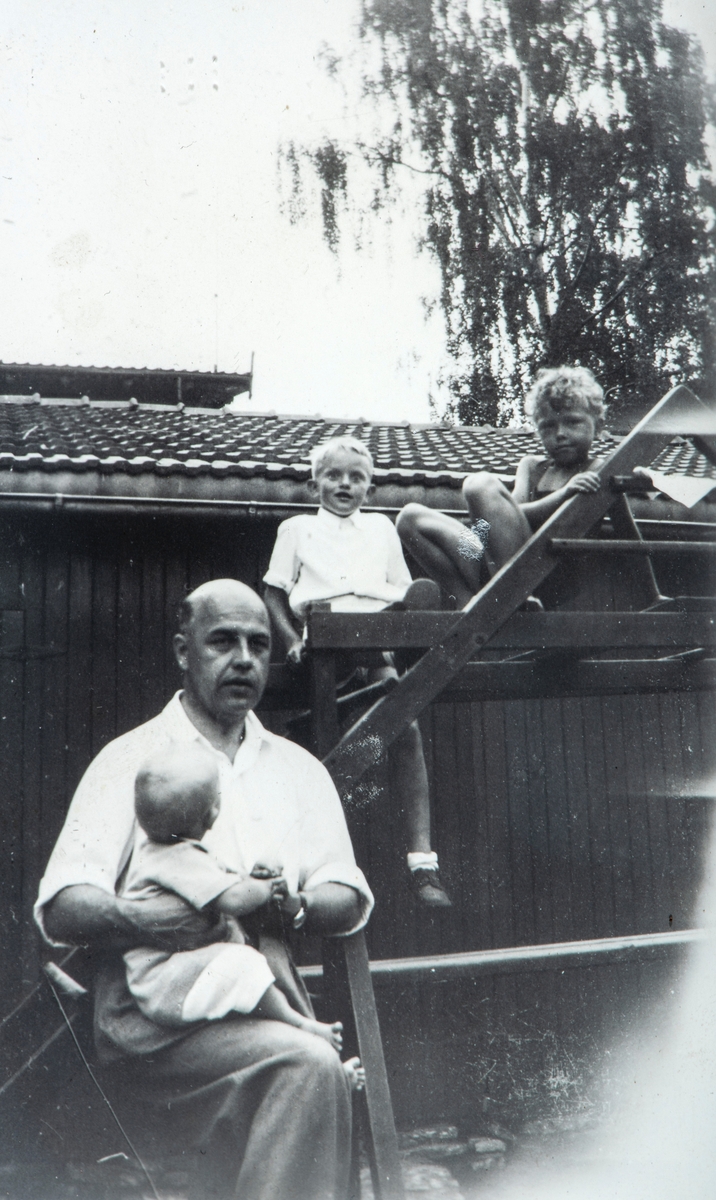 Øyelege Charles Hesselberg med 3 barn, sønnen Arne øverst på klatrestativet, så en ukjent lekekammerat og i nederst Dr. Hesselberg med et barn i fanget.
Tatt inne i haven til Torggata 113 mot nordøst rundt 1953. I bakgrunnen den østre delen av uthuset som lå med baksiden mot Grønnegata 134.