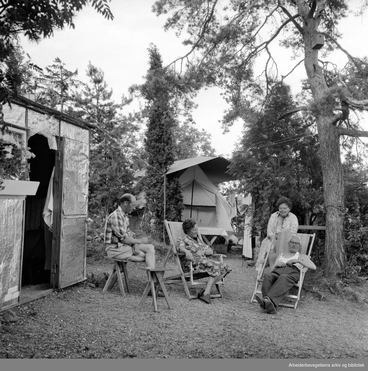 Mange tilbringer sommerferien på Langåra i telt og provisoriske hytter laget av papp. Fra venstre: Harald Børja, Borghild Christensen, Solveig Olsen og Johan Nilsen. Juli 1958