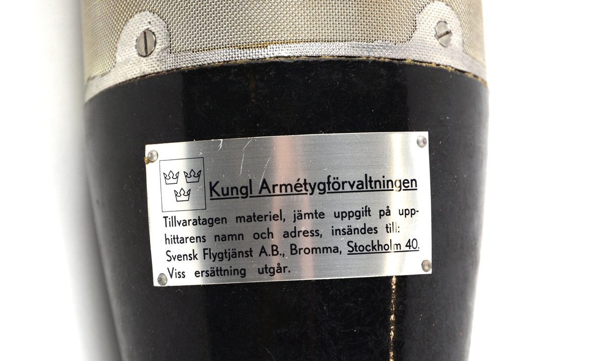 Träffgivare BT-13. Givaren är placerad i en strömlinjeformad kropp av svart bakelit, med ett mittparti av ett perforerat metallrör som klätts med fint metalltrådsnät. Givaren är försedd med ett rött papp-rör som skydd. Förvaras i plastpåse i orginalkartong. Nummermärkt: 4670. Tillverkad av SAAB.