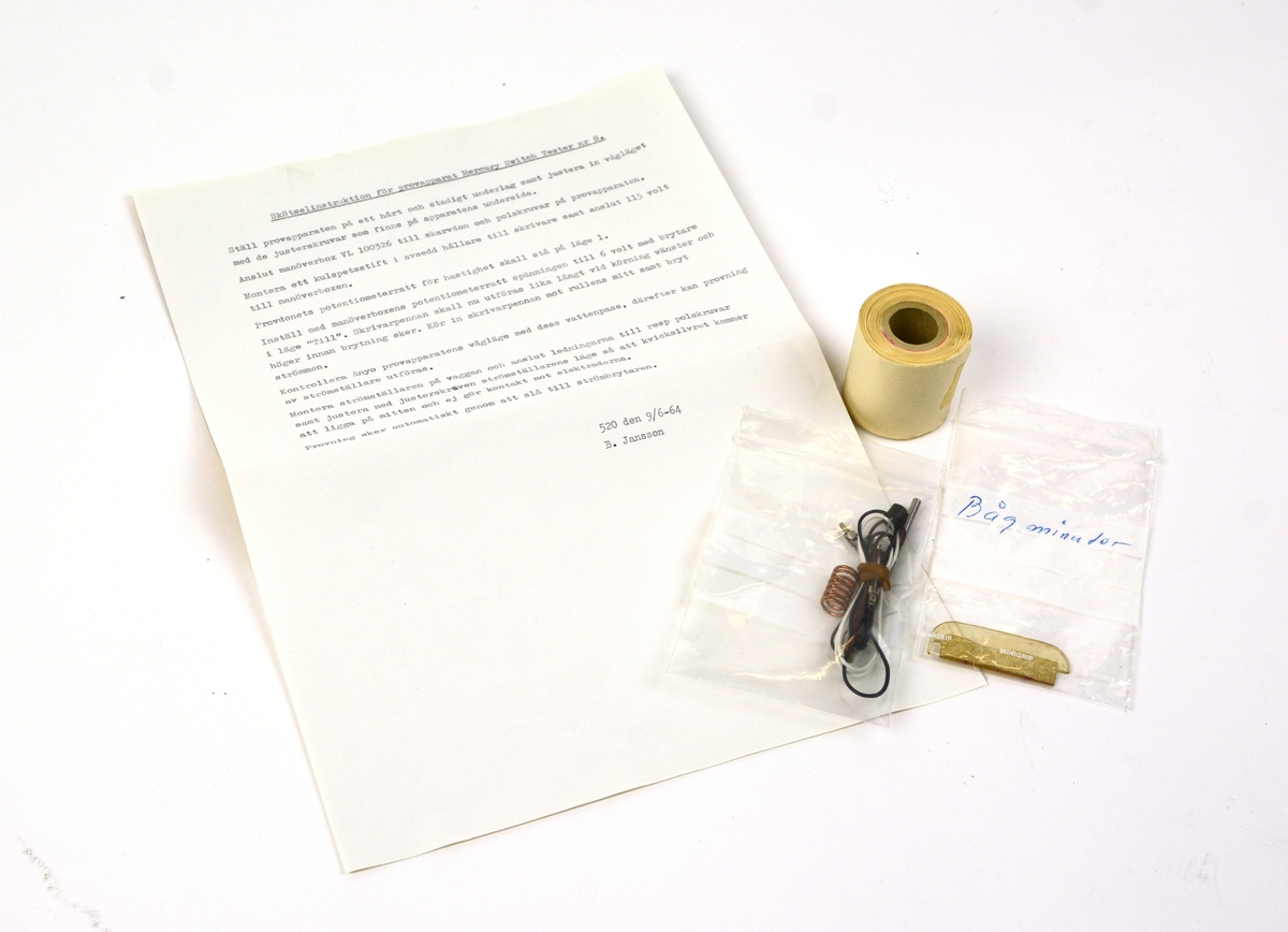 Provapparat kvicksilverströmbrytare. Provutrustning i metall monterad i brun trälåda. Innehåller instruktioner i insidan av locket samt medföljande lös manual med skötselinstruktioner.