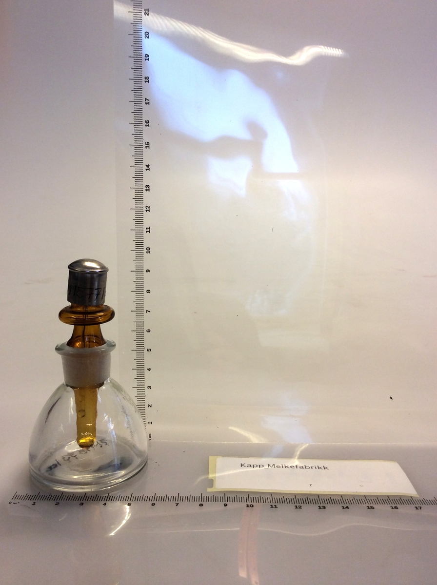 Flaske (A) med avrundet bunn, som hviler på en ring (B) av kork. Flaske brukes for destillasjon. Den har en sidearm som er innstilt på 75 grader til den vertikale aksen. For bruk med termometre kalibrert for 76mm nedsenking.
