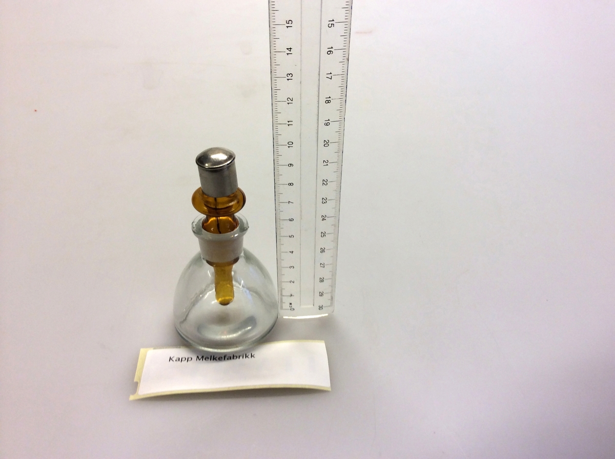 Flaske (A) med avrundet bunn, som hviler på en ring (B) av kork. Flaske brukes for destillasjon. Den har en sidearm som er innstilt på 75 grader til den vertikale aksen. For bruk med termometre kalibrert for 76mm nedsenking.
