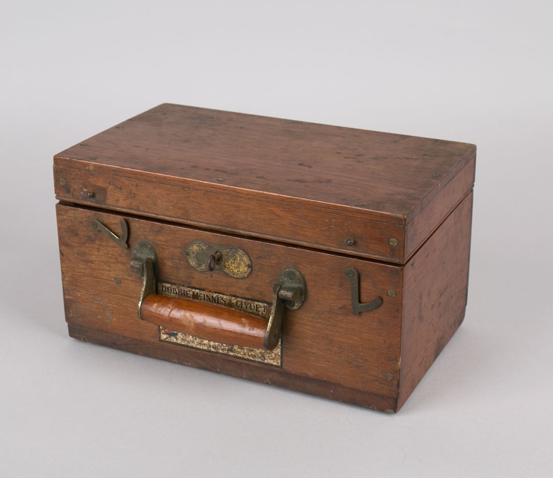 Maskinindikator.  Indikatoren er festet til ene kortsiden av trekasse og vippes ut ved bruk. Kassen har lokk med hengsler, innvendig hengslet plate til romavdeler og oppbevaringsfester for løse deler. 