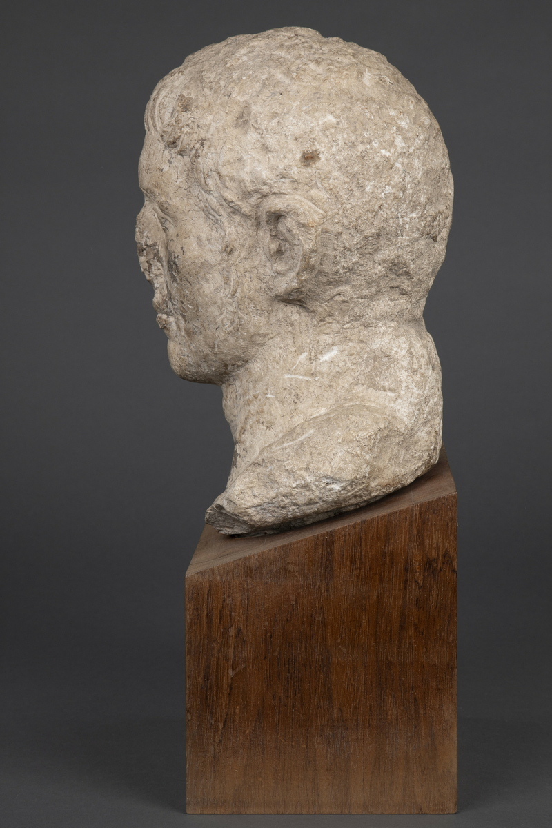 Byste i kalksten på fot av tre.