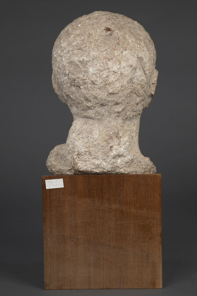 Byste i kalksten på fot av tre.