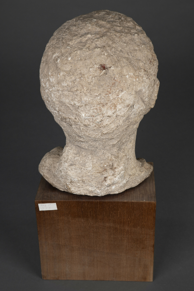 Byste i kalksten på fot av tre.