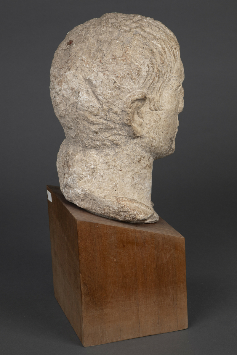 Byste i kalksten på fot av tre.