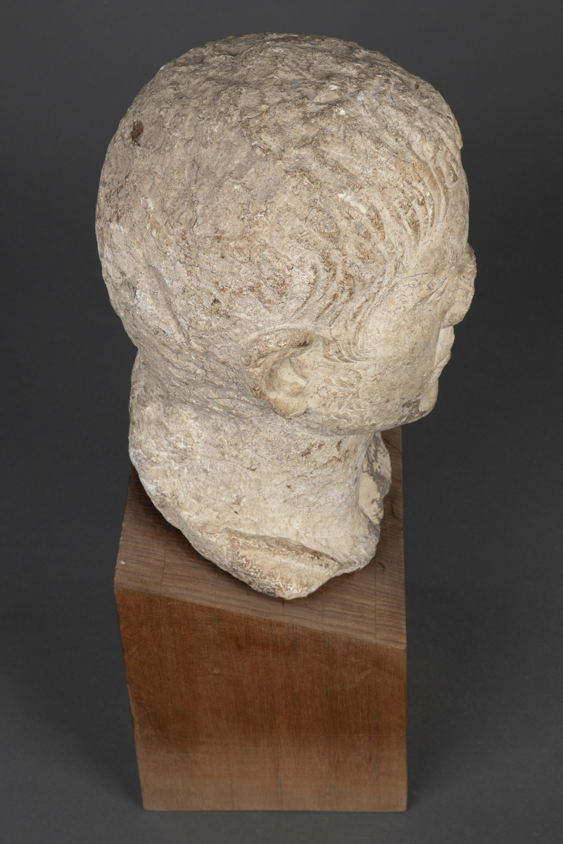 Byste i kalksten på fot av tre.