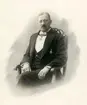 Vinjetterat porträtt av Linköpings stora entreprenör, Jonn O. Nilson. Född under enkla förhållanden på Sturkö i Blekinge kom han till Linköping i september månad 1874 för en tjänst som handelsbetjänt. Han blev snart egen handlare och inledde en anmärkningsvärd levnadsbana med initiativ och ledarskap inom en mängd verksamheter. Hans utbyggnad av vattenkraft ledde till att Linköping kunde elektrifieras från 1902. Hans företag bakom detta, Linköpings Elektriska Kraft & Belysnings AB, kom senare att ombildas till den kommunala energikoncernen Tekniska verken. Linköpings Linnefabrik, Hjulsbro tråddrageri, Hackefors porslin och Nordstjernans knäckebröd är exempel på andra företag han grundade eller satt sin prägel på. Som direktör för järnvägsbolaget Östra Centralbanan var han delaktig i att Linköping spårmässigt kunde knytas till landets sydöstra delar. Slutligen bör nämnas hans bildande av Sydsvenska Banken, där han var direktör till hög ålder. Från 1886 var han gift med Agnes Düring.