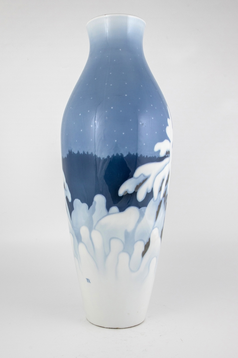 Forgrunnen domineres av et grantre dekket av snø, samt en rekke av mindre trær. I mellomgrunnen skimtes konturene av en mørkeblå ås, mens en blekblå nattehimmel med stjerner utgjør bakgrunnen.