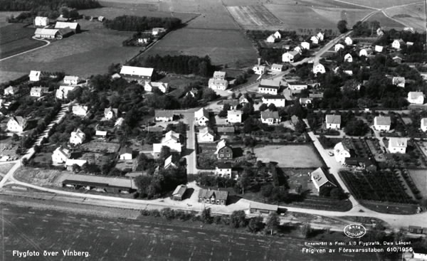Vykort med flygbild över Vinbergs stationssamhälle med "Pyttebanan", Falkenbergs järnväg, och dess station i förgrunden. Enfamiljshus och trädgårdar. Lantgårdar. Byvägar, skog och odlingslandskap.