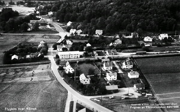 Vykort, "Flygfoto över Köinge". "Äkta fotografi". Falkenbergs Järnväg, "Pyttebanan", går vågrätt genom bilden. Lantgård med uthus. Byvägar. Odlingslandskap, skog.