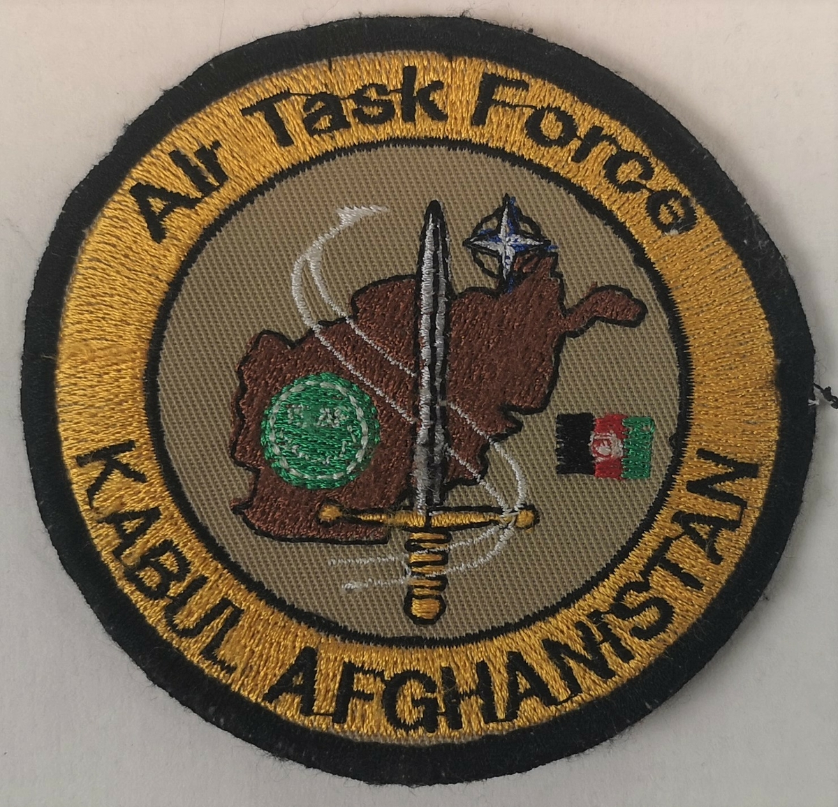 NATO og ISAF logo i sentrum, over kartutsnitt av Afghanistan. 