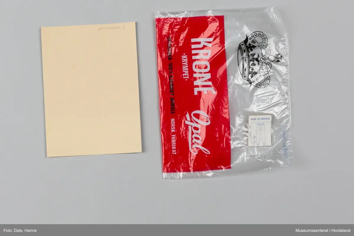 Underbukse med bråt i liv og på bein, gylf, hull ved hoftene, hull til snøring på innsiden av livbråt og korte bein.
Den er pakka i rektangulær plastemballasje med ileggspapp.