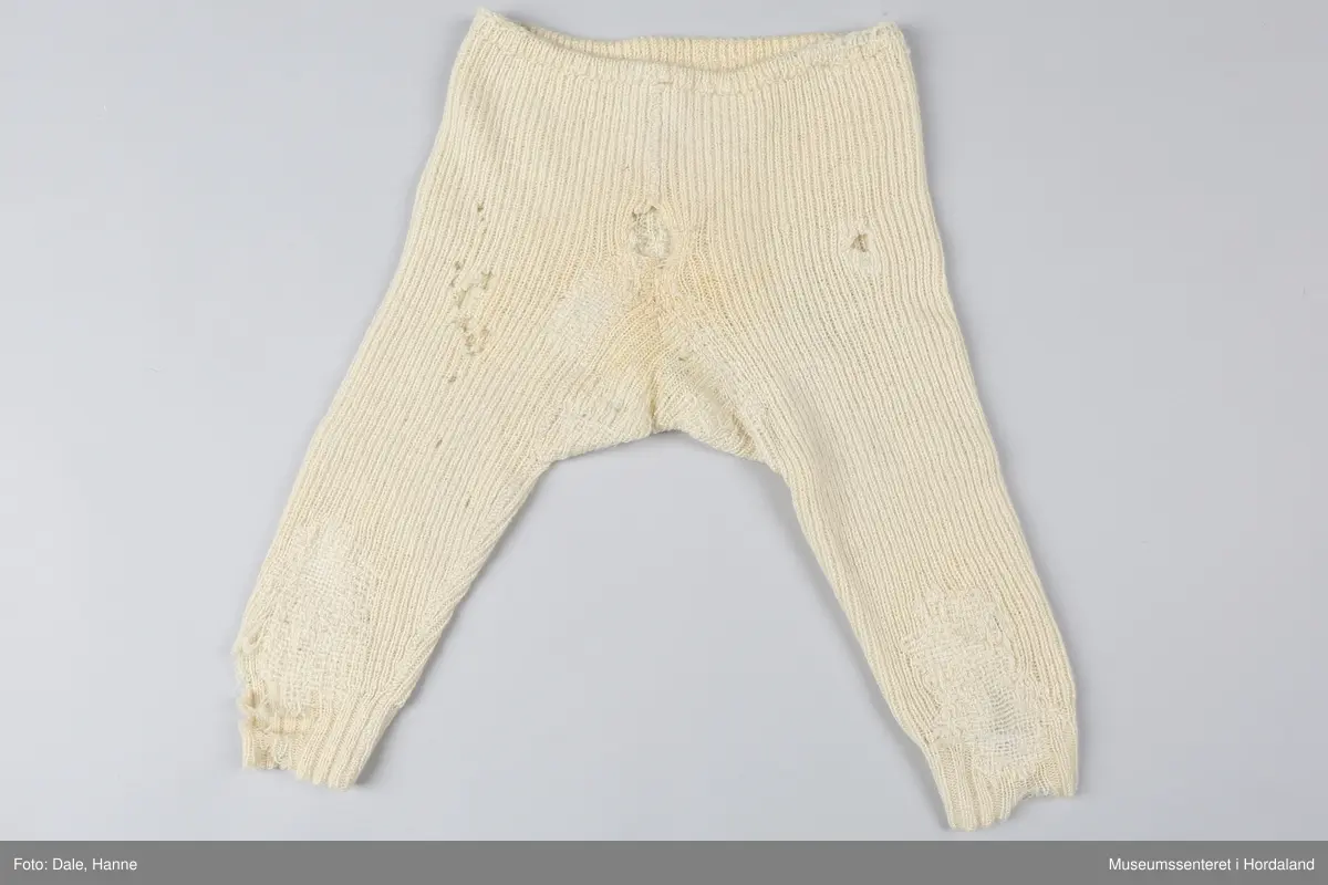 Strikka underbukse med bråt på bein, strikk i livet, sydd saman. Buksa har fleire hol og er stoppa mange gongar på beina og i skrittet.