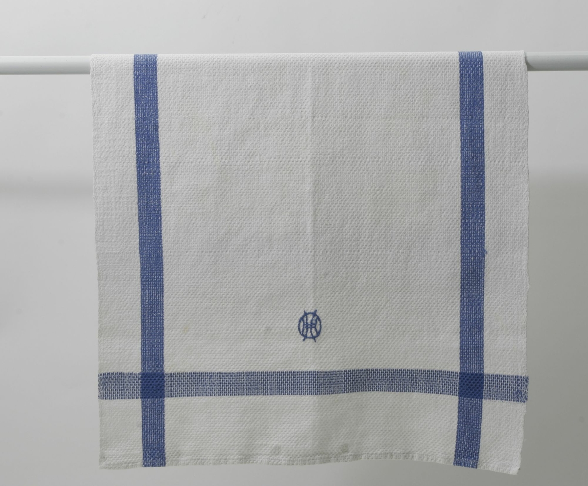Kjøkkenhåndkle som Harstad Husmorlags medlemmer har brodert monogram på
