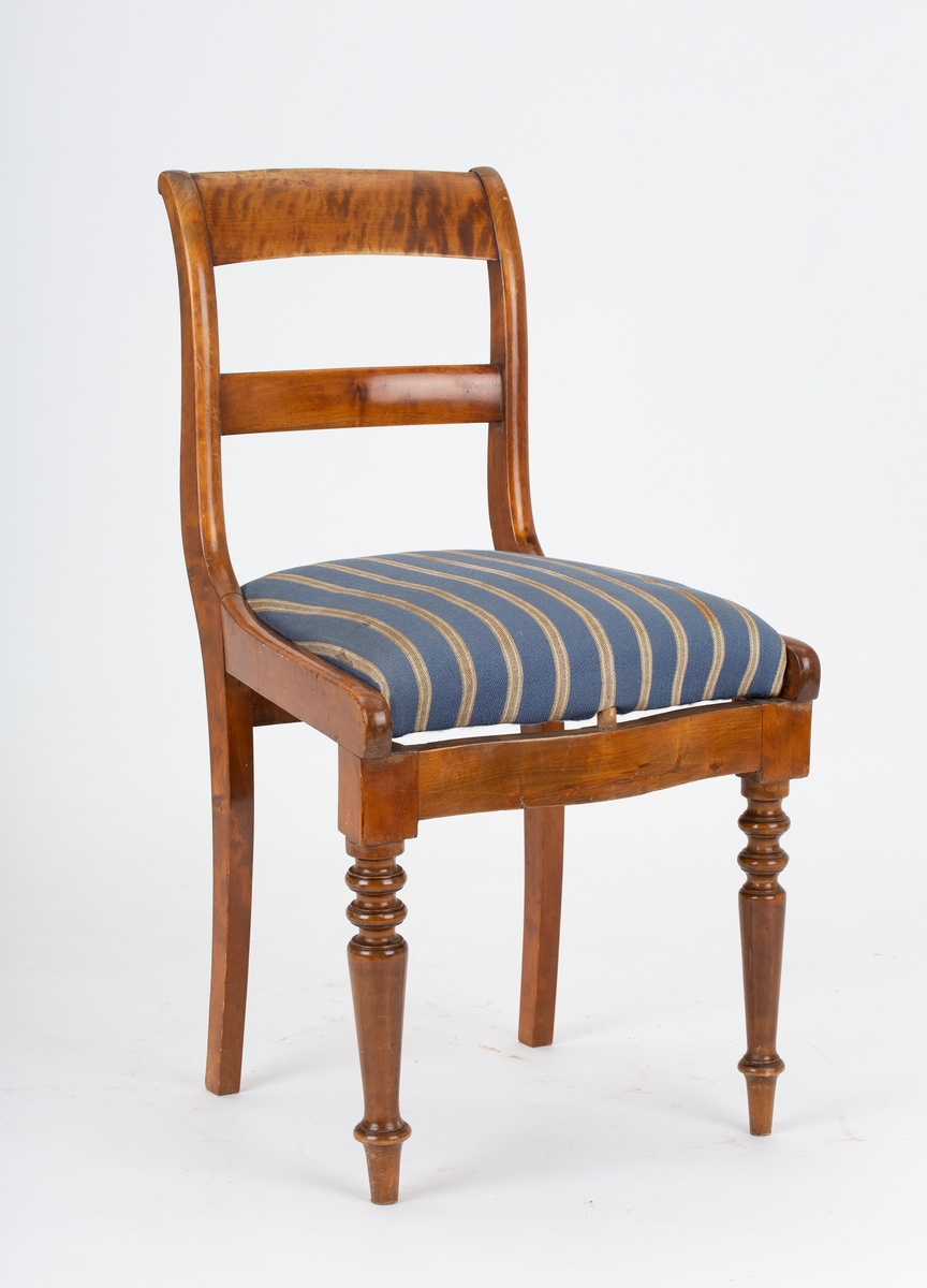 Stol, Biedermeier. Stoppet løst sete, gråblått ullstoff med grå og hvite smale striper. Dreide forben. Svai i rygg og bakben. 2 ryggspiler.
Kaffeflekker på stoltrekkene