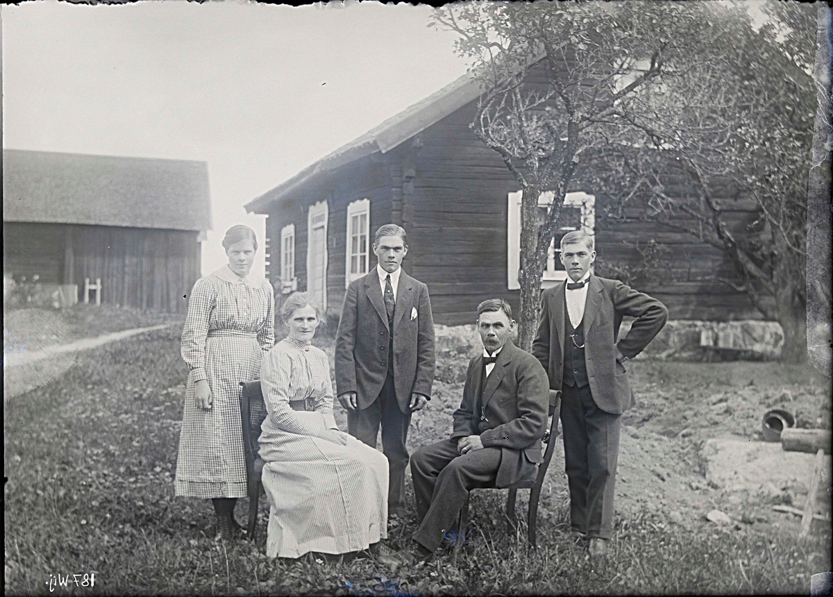 Fotografering beställd av S. Bergqvist. Föreställer hemmansägaren Klas Otto Bergqvist (1865-1953), hans hustru Kristina Vilhelmina f. Jansson (1869-1923) samt tvillingsönerna Gustaf Alfred (1897-1979) och Karl Gunnar (1897-1986). Kvinnan till vänster är Gunnars hustru Ally Eugenia Pettersson (1898-1979). Bilden är sannolikt tagen i samband med Kristinas 50-årsdag.