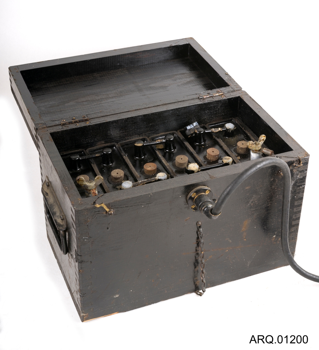 Signallampe/morselampe med batteri. Begge i svart farge. Batteriet ligger oppe i en trekasse som også er malt svart. Det hører også med en løs knott, som antagelig har falt av batteriet.
Det er en lampe av type Aldis Lantern produsert i Canada. Ved trykk på håndtaket bever speilet inne i lampen seg, med strøm og lys i lyspæren kan man da sende "SOS" ved nødsituasjoner. Lampen har et sikte på toppen.
Selve batteriet er tungt og består av 6 elementer satt sammen med ulike koblinger.