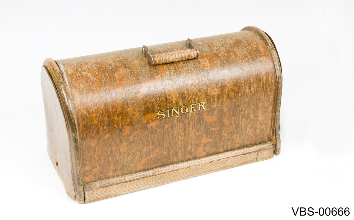 Maskinen har gullfarget mønster og skrift.
SINGER merkevare og påskriften "The Singer Manufackting company" pryder frontsiden med gullfarger motiver.