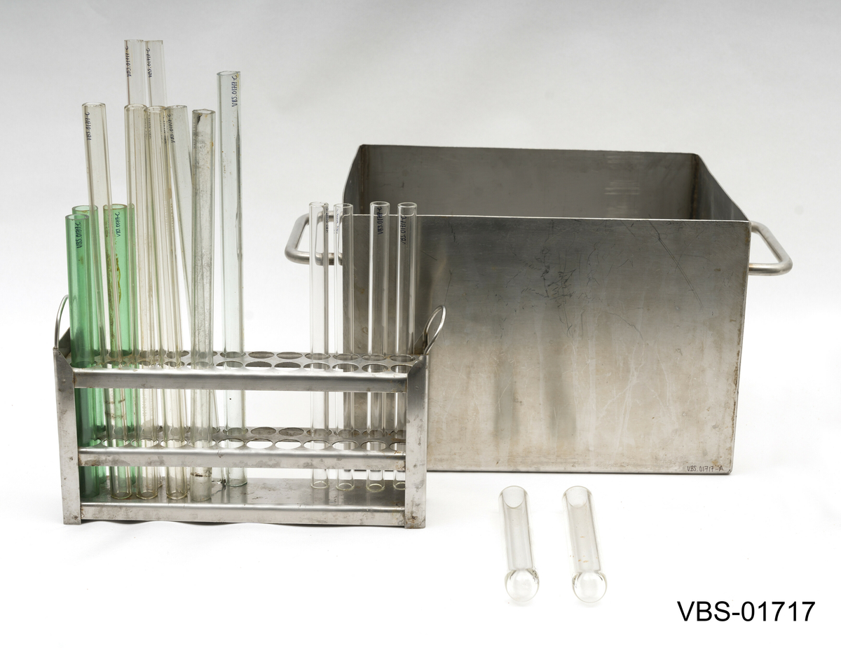 Aluminiums eske med, uten lokk, og to håndtak. Den inneholder et metallstativ med flere reagensrørholder eller glassrør.
Aluminiums eske (A), stål stativ (B) og glassrør (C) på bilder.

Glassrør settet består av: 
2 hvite glass prøverør (13x2cm diameter). Brukte.
3 grønne glassrør (20x1,5 cm diameter). Brukte.
5 hvite glassrør (28x1,5 cm diameter). Brukte.
3 hvite glassrør (50x1,5 cm diameter). Brukte.
4 nye hvite glassrør (28x1,5 cm diameter). Brukte.