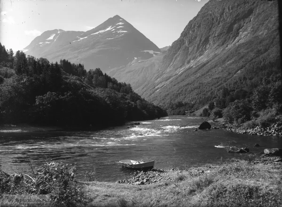 Eira, Hekshølen, Eresfjorden. T.v. Øverås-sida med Sjøvdøla og Nebbå og Røndølsskaret o bakgrunnen. Elvaferje brukt av laksefiskarar.