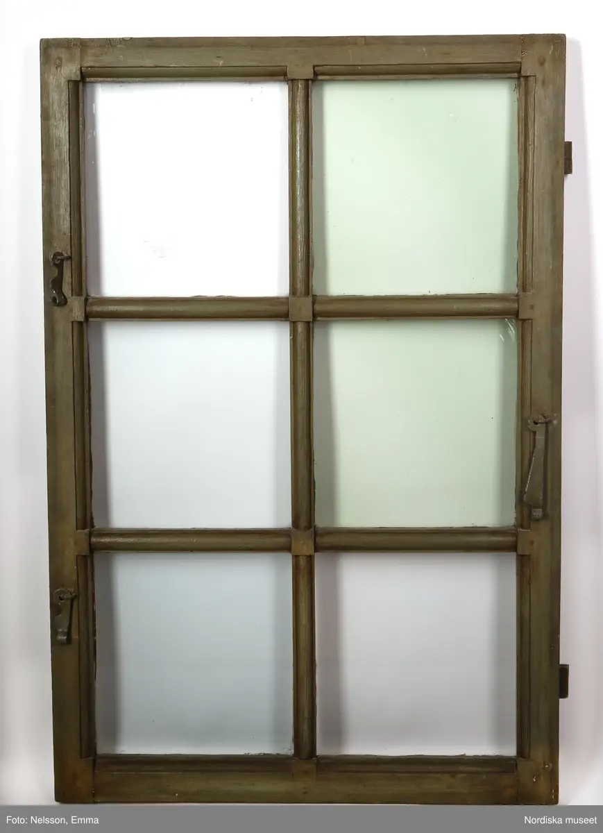 a-d) Fönster med e) karm, fyra fönsterbågar med vardera sex glasrutor, omkring 1740. Utvändigt målat brunt, invändigt grågrön oljefärg. 

Utåtgående fönsterbåge. Träspröjsar med en på insidan rundad vulst som möts i kvadratiskt spröjskryss. Bågens yttersida förstärkt med hörnjärn av 1700-talstyp. Fönsterkarm av furu med symmetrisk korspost. Fönsterbleck av målad plåt, fäst i karmens nederkant. Med fönsterbräda. Beslag för hängning av fönsterluckor. Gångjärn, uppställnings- och stängningsbeslag.  

Anm: Partiellt färgbortfall och skador. Ett av tre fönster(NM.0334543-NM.0334545), placerat på rummets långsida, mot gatan.
/Anna Arfvidsson Womack 2021-07-14