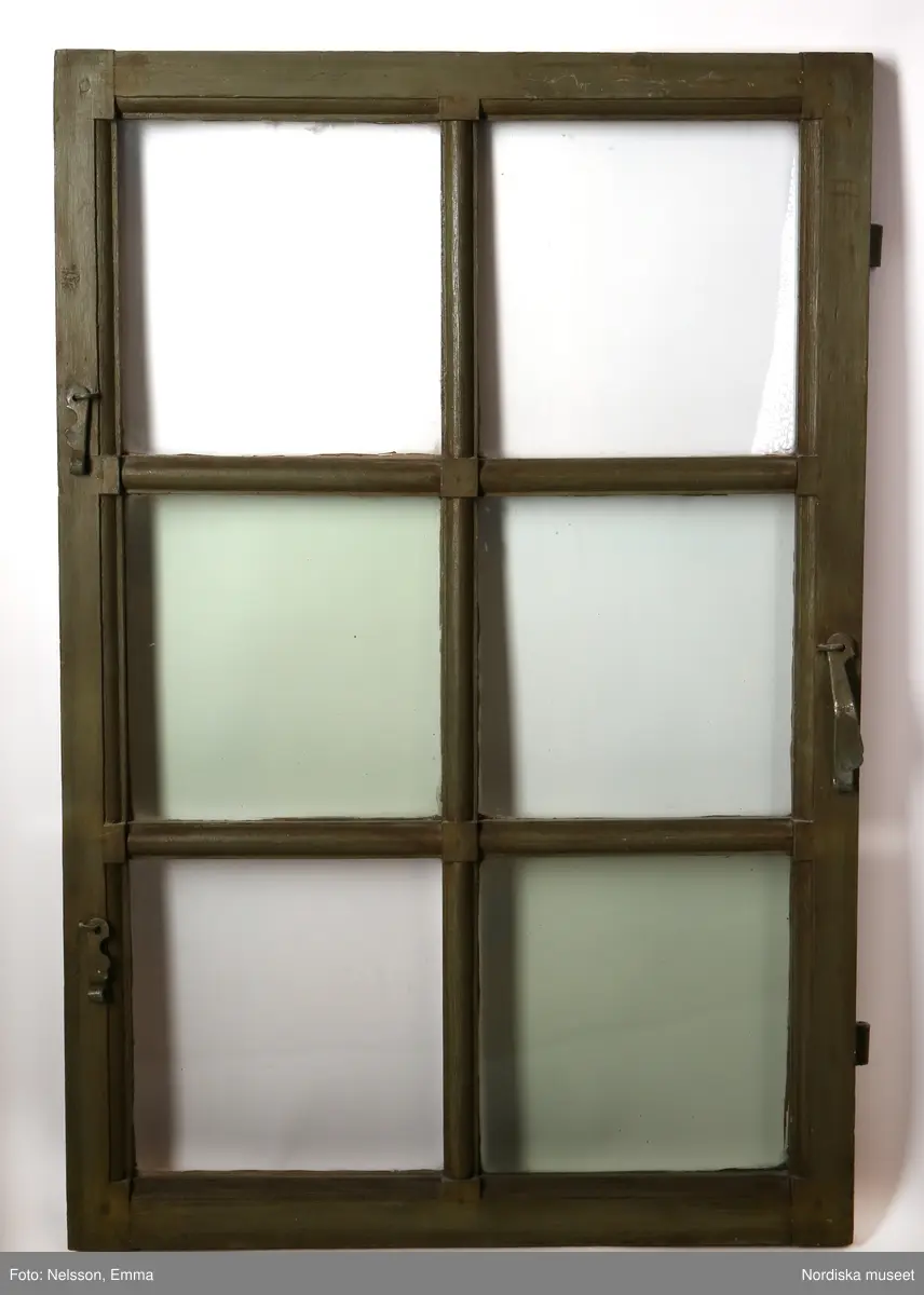 a-d) Fönster med e) karm, fyra fönsterbågar med vardera sex glasrutor, omkring 1740. Utvändigt målat brunt, invändigt grågrön oljefärg. 

Utåtgående fönsterbåge. Träspröjsar med en på insidan rundad vulst som möts i kvadratiskt spröjskryss. Bågens yttersida förstärkt med hörnjärn av 1700-talstyp. Fönsterkarm av furu med symmetrisk korspost. Fönsterbleck av målad plåt, fäst i karmens nederkant. Med fönsterbräda. Beslag för hängning av fönsterluckor. Gångjärn, uppställnings- och stängningsbeslag.  

Anm: Partiellt färgbortfall och skador. Ett av tre fönster(NM.0334543-NM.0334545), placerat på rummets långsida, mot gatan.
/Anna Arfvidsson Womack 2021-07-14