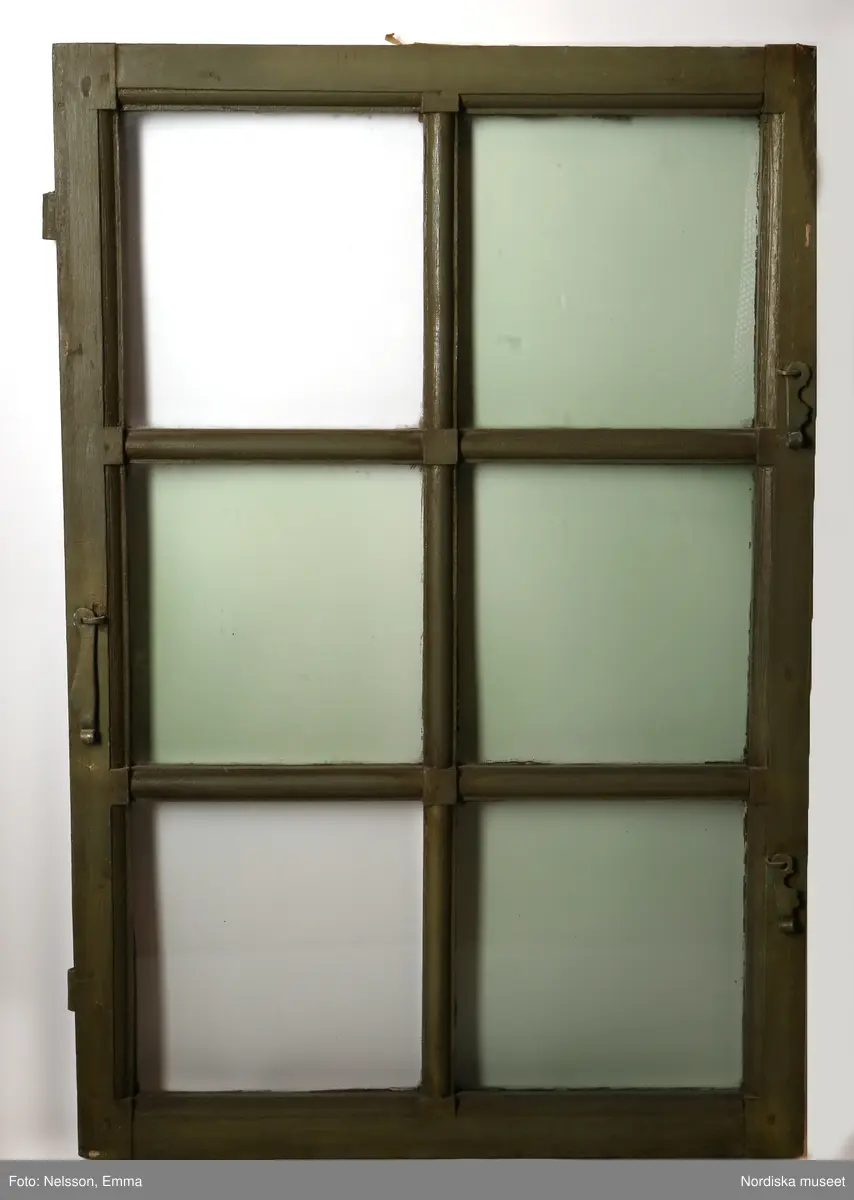 Fönster med karm, fyra fönsterbågar med vardera sex glasrutor, omkring 1740. Utvändigt målat brunt, invändigt grågrön oljefärg. 

Utåtgående fönsterbåge. Träspröjsar med en på insidan rundad vulst som möts i kvadratiskt spröjskryss. Bågens yttersida förstärkt med hörnjärn av 1700-talstyp. Fönsterkarm av furu med symmetrisk korspost. Fönsterbleck av målad plåt, fäst i karmens nederkant. Med fönsterbräda. Beslag för hängning av fönsterluckor. Gångjärn, uppställnings- och stängningsbeslag.  

Anm: Partiellt färgbortfall och skador. Ett av tre fönster, placerat på rummets långsida, mot gatan.
/Anna Arfvidsson Womack 2021-07-14