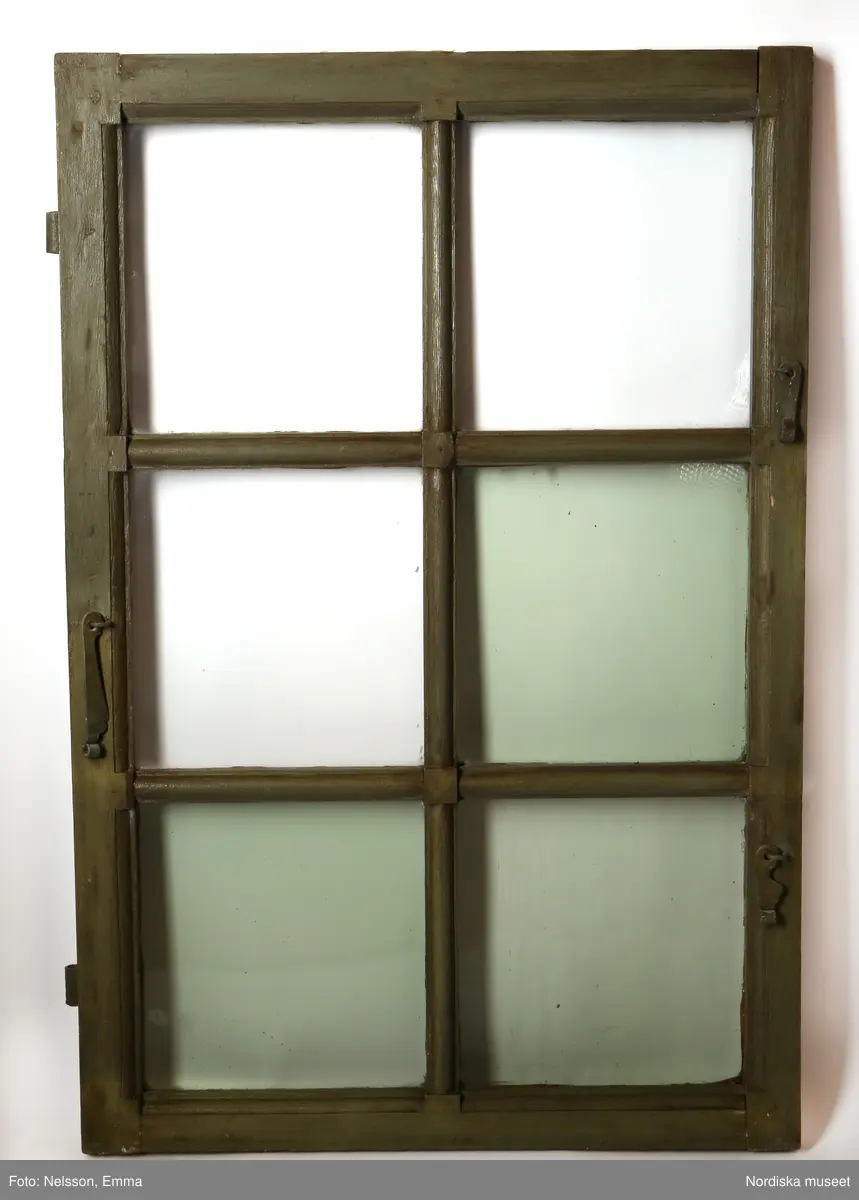 Fönster med karm, fyra fönsterbågar med vardera sex glasrutor, omkring 1740. Utvändigt målat brunt, invändigt grågrön oljefärg. 

Utåtgående fönsterbåge. Träspröjsar med en på insidan rundad vulst som möts i kvadratiskt spröjskryss. Bågens yttersida förstärkt med hörnjärn av 1700-talstyp. Fönsterkarm av furu med symmetrisk korspost. Fönsterbleck av målad plåt, fäst i karmens nederkant. Med fönsterbräda. Beslag för hängning av fönsterluckor. Gångjärn, uppställnings- och stängningsbeslag.  

Anm: Partiellt färgbortfall och skador. Ett av tre fönster, placerat på rummets långsida, mot gatan.
/Anna Arfvidsson Womack 2021-07-14
