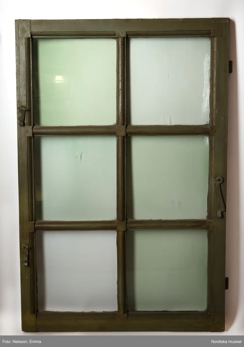 Fönster med karm, fyra fönsterbågar med vardera sex glasrutor, omkring 1740. Utvändigt målat brunt, invändigt grågrön oljefärg. 

Utåtgående fönsterbåge. Träspröjsar med en på insidan rundad vulst som möts i kvadratiskt spröjskryss. Bågens yttersida förstärkt med hörnjärn av 1700-talstyp. Fönsterkarm av furu med symmetrisk korspost. Fönsterbleck av målad plåt, fäst i karmens nederkant. Med fönsterbräda. Beslag för hängning av fönsterluckor. Gångjärn, uppställnings- och stängningsbeslag.  

Anm: Partiellt färgbortfall och skador. Ett av tre fönster, placerat på rummets långsida, mot gatan.
/Anna Arfvidsson Womack 2021-07-14