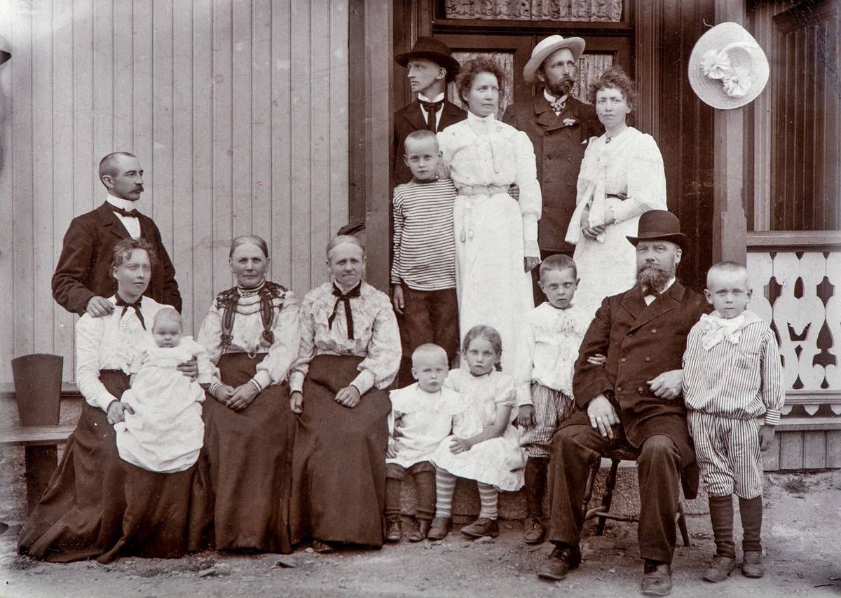 Hamar, skreddermester Johan Eriksen med familie, gruppe 15 personer. Fra venstre : lærer Amund Gulden (1873-), foran sitter kona lærer Laura Gulden født Eriksen (1873-), med datter Hjørdis på fanget. Så 2 ukjente damer, liten gutt: Jens (???), Marta Melhus, Reidar Sannerud (1898-), Skreddermester Johan Eriksen (1840-1916) og Erling Sannerud. 
Bak: Erling ( ? ), Marie Sannerud, Otto ( ? ) , Betzy ( ? ) , Jan ( ? ),