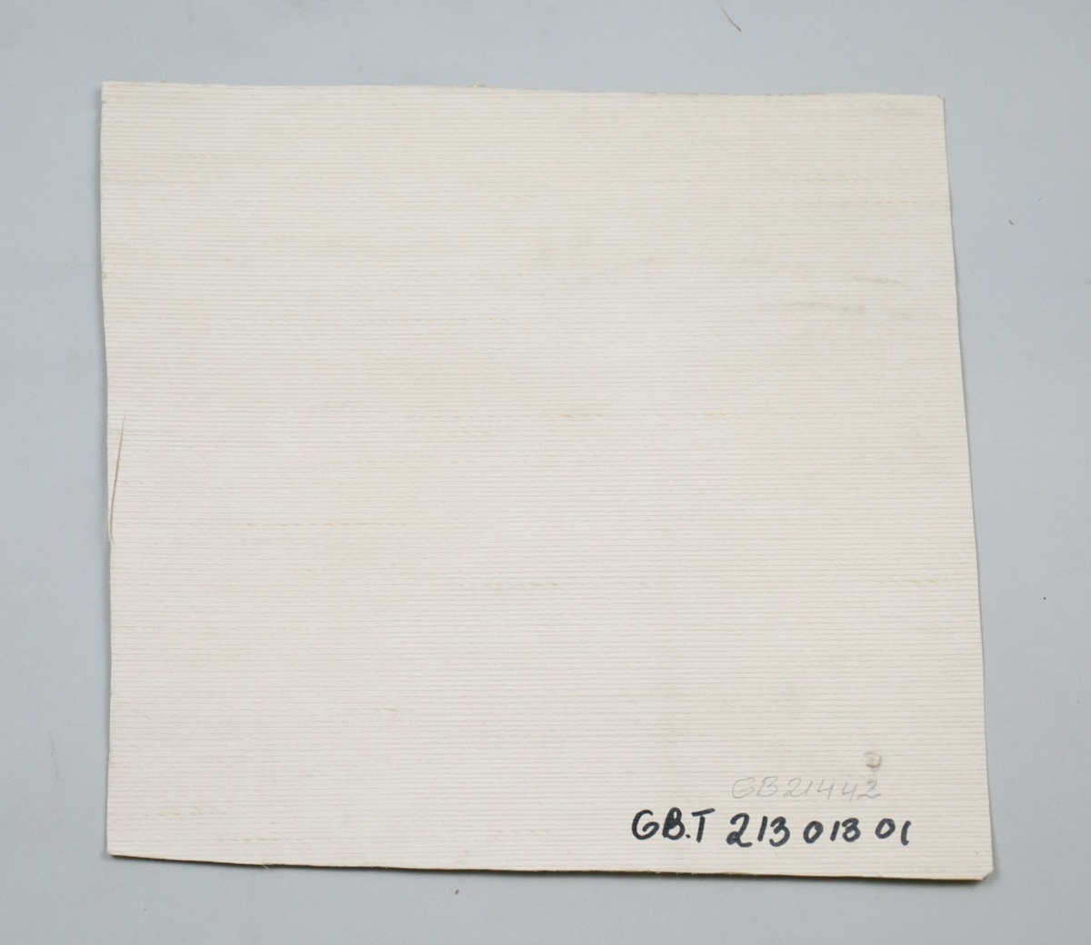 Tekstilimitasjon i lys beige.