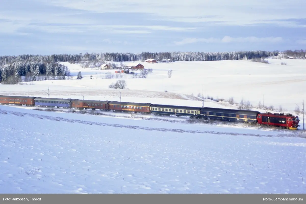 Elektrisk lokomotiv El 16 2204 med persontog fra Hamburg til Oslo S, tog 280, ved km 28,5 like syd for Holstad stasjon på Østfoldbanen