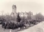 Växjö domkyrka, ca 1900. 
En okänd äldre man och några pojkar poserar för fotografen vid ett antal granitstolpar, i kanten av blivande Linnéparken.