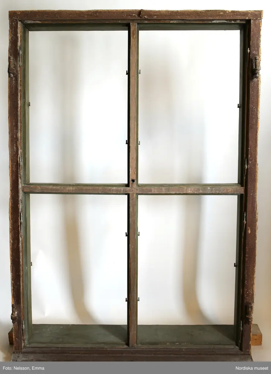 Fönster med karm, fyra fönsterbågar med vardera sex glasrutor, omkring 1740. Utvändigt målat brunt, invändigt grågrön oljefärg. 

Utåtgående fönsterbåge. Träspröjsar med en på insidan rundad vulst som möts i kvadratiskt spröjskryss. Bågens yttersida förstärkt med hörnjärn av 1700-talstyp. Fönsterkarm av furu med symmetrisk korspost. Fönsterbleck av målad plåt, fäst i karmens nederkant. Med fönsterbräda. Beslag för hängning av fönsterluckor. Gångjärn, uppställnings- och stängningsbeslag.  

Anm: Partiellt färgbortfall och skador. Ett av tre fönster, placerat på rummets långsida, mot gatan.
/Anna Arfvidsson Womack 2021-07-14