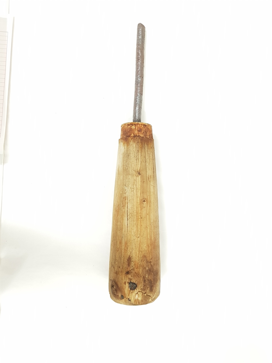 Et dreid trestykke med en jernstang festet i et hull i den avsmalende enden