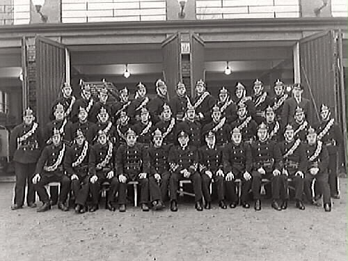 Varbergs brandkår år 1938. Manskapet uppställda framför brandstationen.  som låg utmed Engelbrektsgatan, intill Varbergs teater.