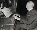 Kantor Erik Blank spelar på en kammarorgel. Lessebo, ca 1960.