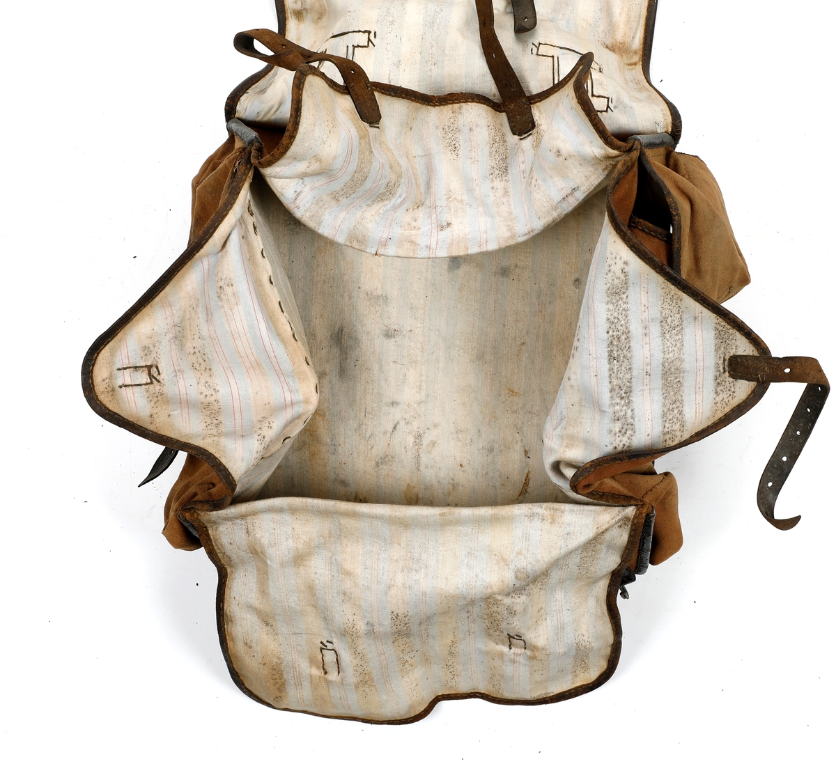Militærransel i tekstil med kantet med lær. Lommer på hver side av ranselen. Foret med tekstil i bomull. Skulderreimer i læs, hvorav en kan festes til en metallspenne og den andre til en hekte. To doble smøystole på toppen av ranselen. Under lokket er det fire klaffer, to reimer i lær på ytre klaff og en reim på indre klaffer, som som festes til metallspenner. Ranselen er misformet.