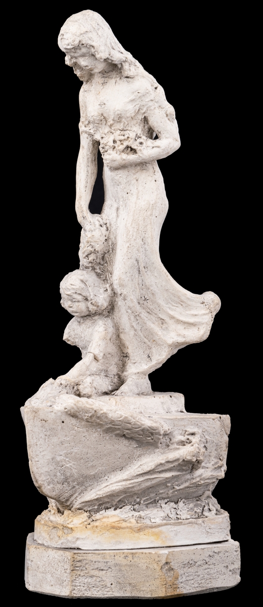 Skulpturskiss av Ida Matton, signerad Paris 1920, till gravmonument för redarfamiljen Brodin i Gävle. Kvinna med blommor i händerna med ett barn med blomgirlang sittande framför fötterna. Båda placerade på en trekantig sockel som liknar stäven på en båt.