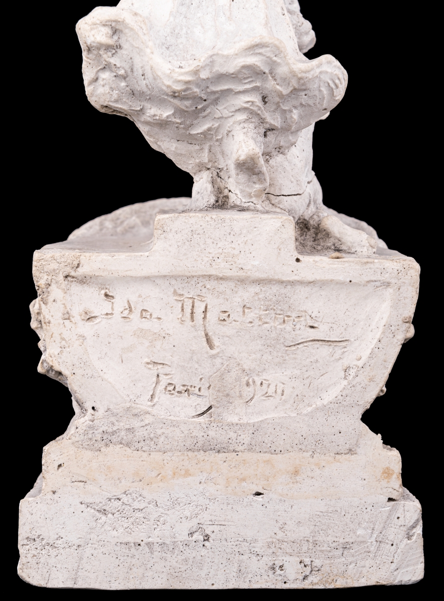 Skulpturskiss av Ida Matton, signerad Paris 1920, till gravmonument för redarfamiljen Brodin i Gävle. Kvinna med blommor i händerna med ett barn med blomgirlang sittande framför fötterna. Båda placerade på en trekantig sockel som liknar stäven på en båt.