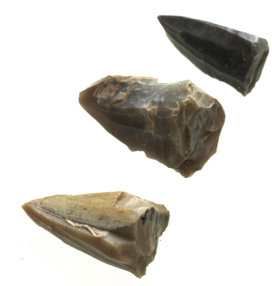 3 typiske koniske flekkekjerner, den ene av lys grå, de to andre av mørk grå flint. Lengde 2,7-3,2 cm.