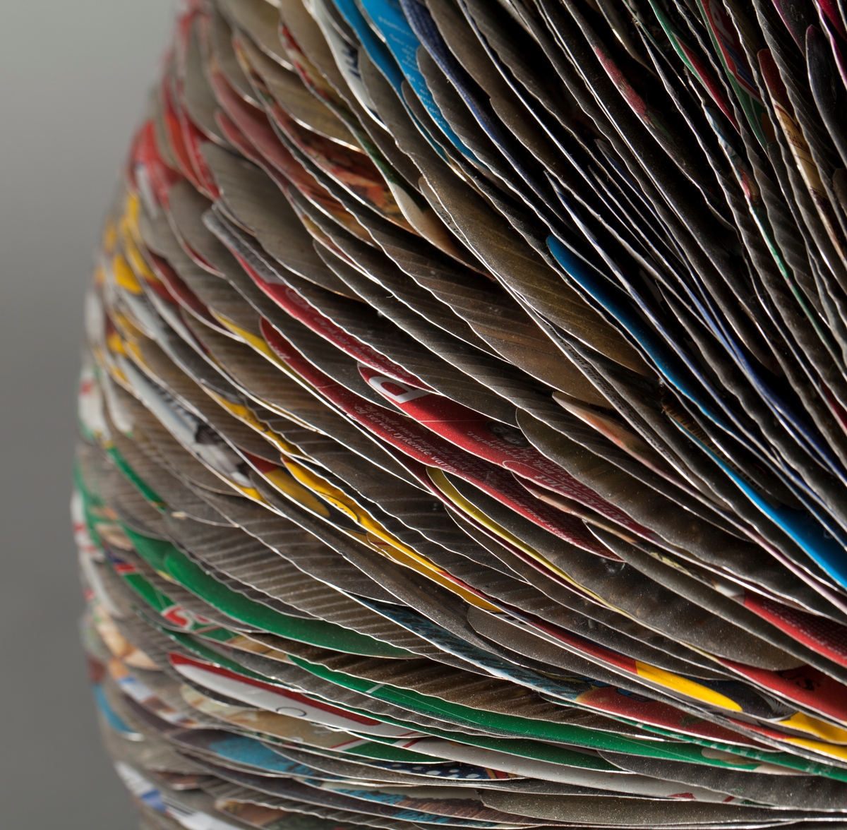 Eggformet skulptur, satt sammen av utallige tilskårede metallplater fra hermetikkbokser. Metallplatene er festet lag på lag rundt en akse og kan minne om formen til en kongle.