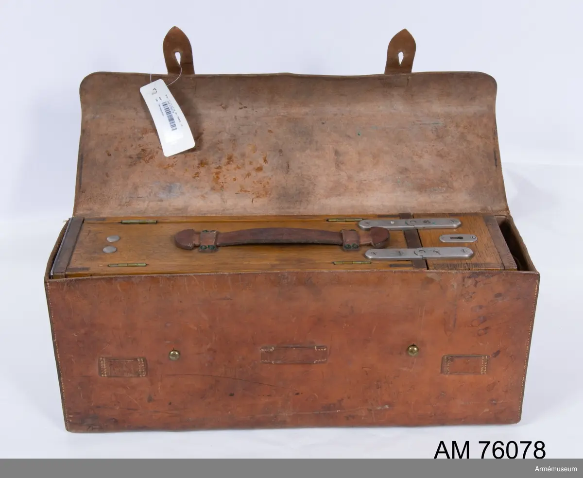 Grupp G IV.

Tändapparat m/1886-11, fabrikat Lundell.
Tändapparat av trä med fodral av läder.

Utdrag ur "Ingenjörtruppernas Fältarbeten Del V A. Förstöringsarbeten" (Fältarb. V A Ing.) 1932 års upplaga sid 190-193

Tändapparater.
Tändapparat m/86-11 är en medelst handkraft driven elektrisk likströmgenerator, innesluten i ett fodral av trä med två dörrar, försedda med låsinrättningar. Låsen öppnas medelst tryckknappar. Till fodralet hör lock med lås och nyckel. Upptill finnas 2 kontaktskruvar, polskruvar, för ledningens inkopplande, 1 kuggstång med handtag och 1 glödlampa.

Strömmen alstras genom kuggstångens kraftiga nedskjutande så långt den går.

För apparatens provning kan strömmen medelst en omkastare, konstruerad såsom en tryckknapp, ledas genom glödlampan. Denna provning får icke verkställas med inkopplad tändledning, enär strömmen, om avbrott förefinnes i lampledningen, går ut i tändledningen och tänder där inkopplade tändare. Inträffar vid provning ej glödning, förefinnes fel hos apparaten.

Inuti locket finnes ett mindre rum för reservdelar och trassel. i nedre delen av fodralet är plats för 3 tändarfodral m/92

Elektriska tändare.
Då elektriska tändare m/28 hava ett litet motstånd (omkring 1,4 ohm), hava tändare av äldre modell ett jämförelsevis stort motstånd (vanligen 5-10 ohm). Tändare av äldre modell äro avsedda för koppling i bredd och skola alla i samma ledning hava lika motsånd. En skillnad i motståndet av högst 1 ohm må dock tillåtas.

Det högsta antal tändare av äldre modell, som vid koppling i bredd och i en linje kunna tändas, är med
   tändapparat m/86-11                } 20 st.
          "            större, m/16          } 20 st.
          "            för 30 skott m/27  } 20 st.
          "            för 3 skott m/27        3 st.

Det högsta antal tändare m/28, som vid koppling i följd kan tändas, är med
   tändapparat m/86-11        } 20 st.
          "            större, m/16  } 20 st.