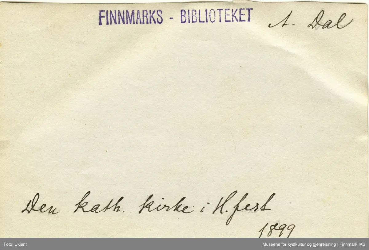 Den katolske kirken i Hammerfest i 1899. Til venstre for den står det trehus med skifertak. Foran husene står det en flagmast med et vaiende  norgesflagg. Nede i midten av bildet står en liten båt og ved siden av sitter tre men på en benk. Til venstre for dem er det en uniformert person. Arbeidsfolk er å se ved pakkhuset. Oppe på veien står det en kvinne og to barn. En man sitter med et barn i fanget på muren. Det virker som om innbyggerne i Hammerfest nyter godværet.  I fjellsida til Salen ligger det fortsatt litt sne. Oppe på Salenfjellet ser man varden.